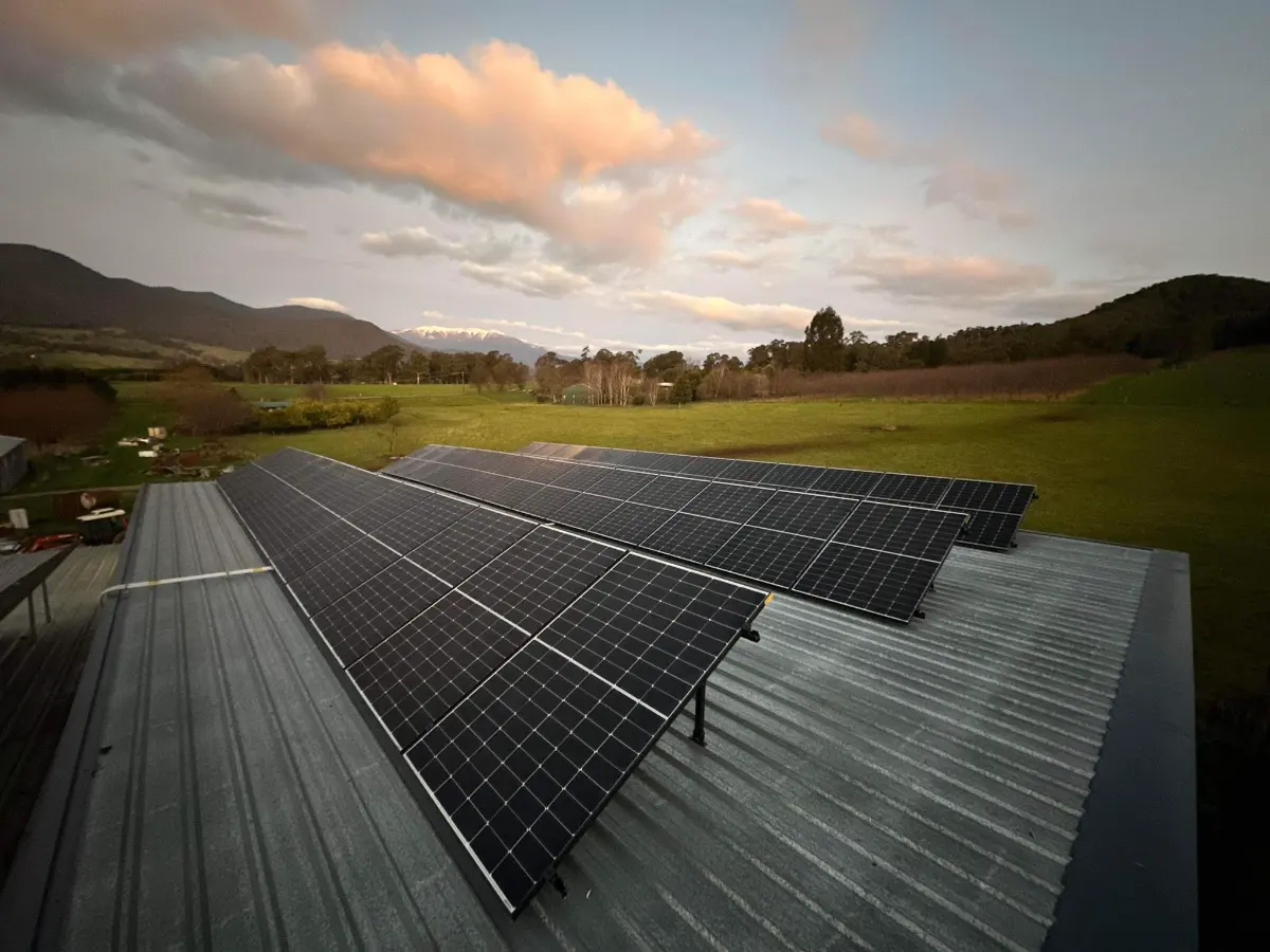Rows of solar panels on a shed roof at sunset, installed by CES